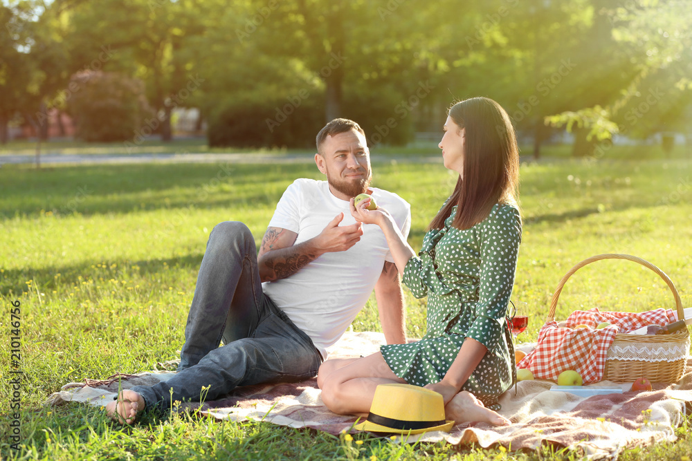 Happy couple having picnic in park on spring day