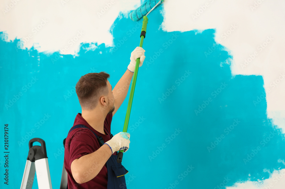 Male painter in uniform working indoors