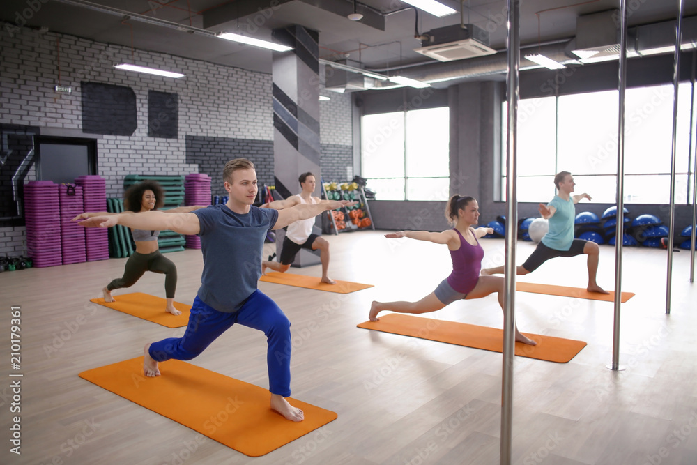 Young people doing yoga in gym