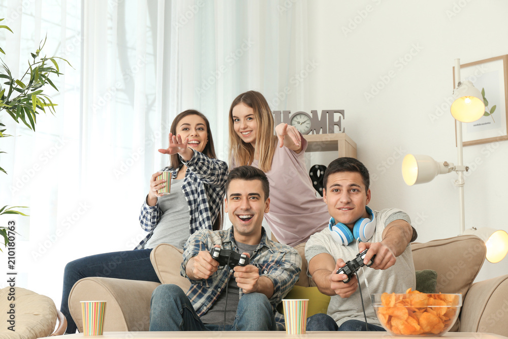 Young people playing video games at home