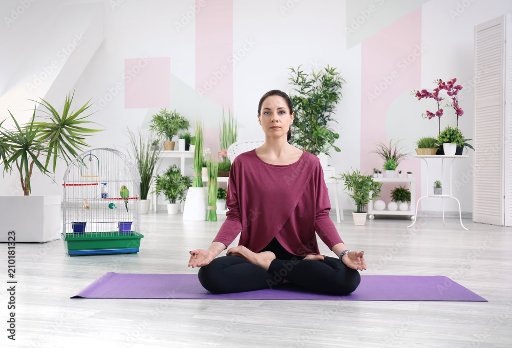 Young woman practicing yoga at home