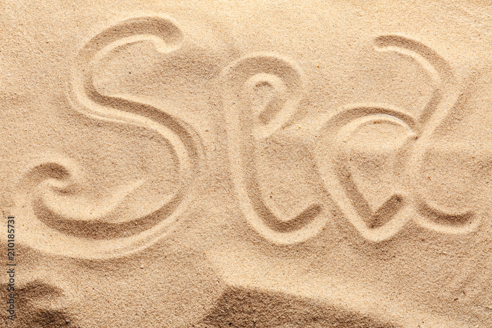 Word SEA written on beach sand