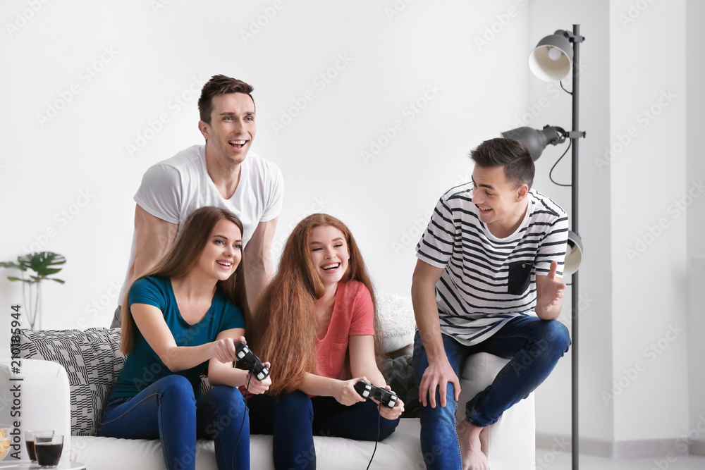 Young people playing video games at home