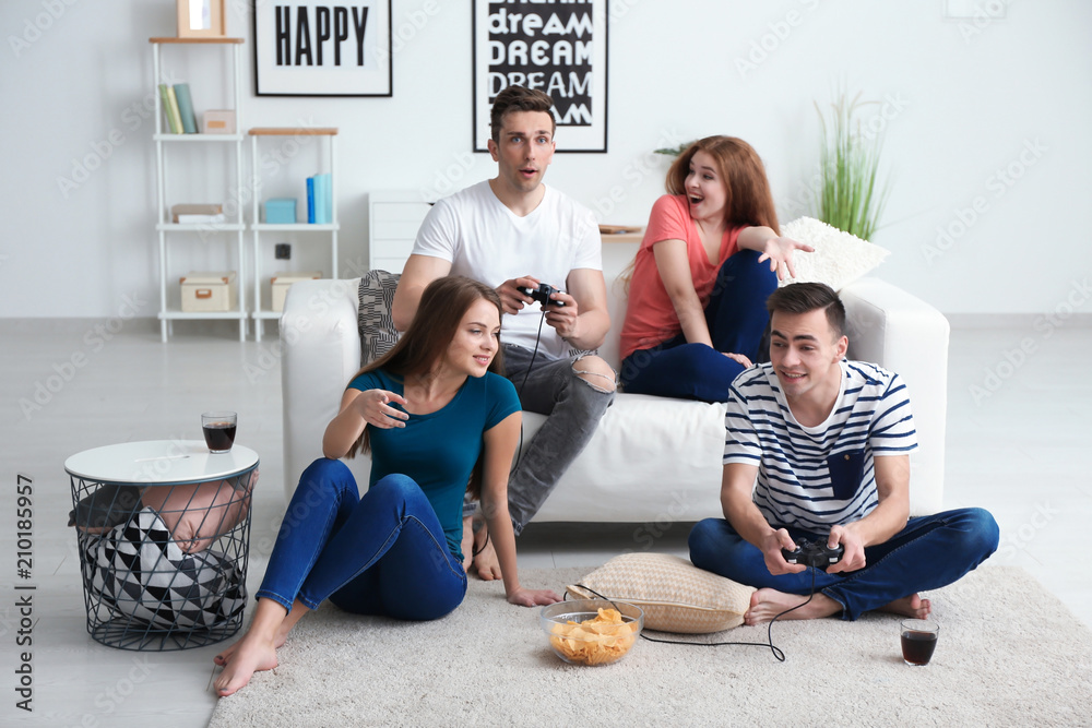 Young people playing video games at home