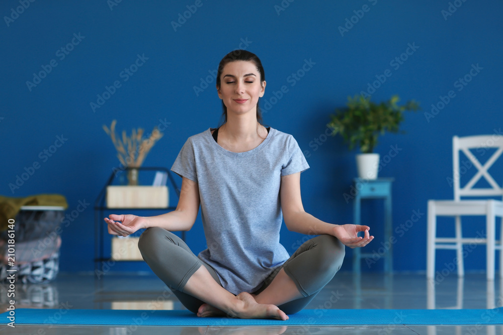 Young woman practicing yoga indoors