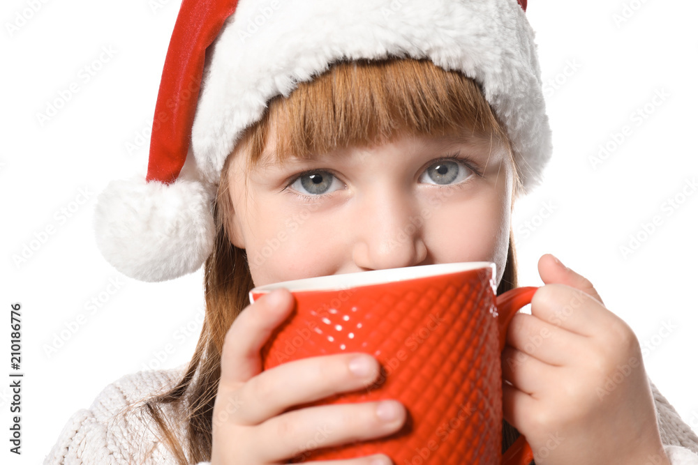 Cute little girl in Santa hat and with cup of hot cocoa drink on white background