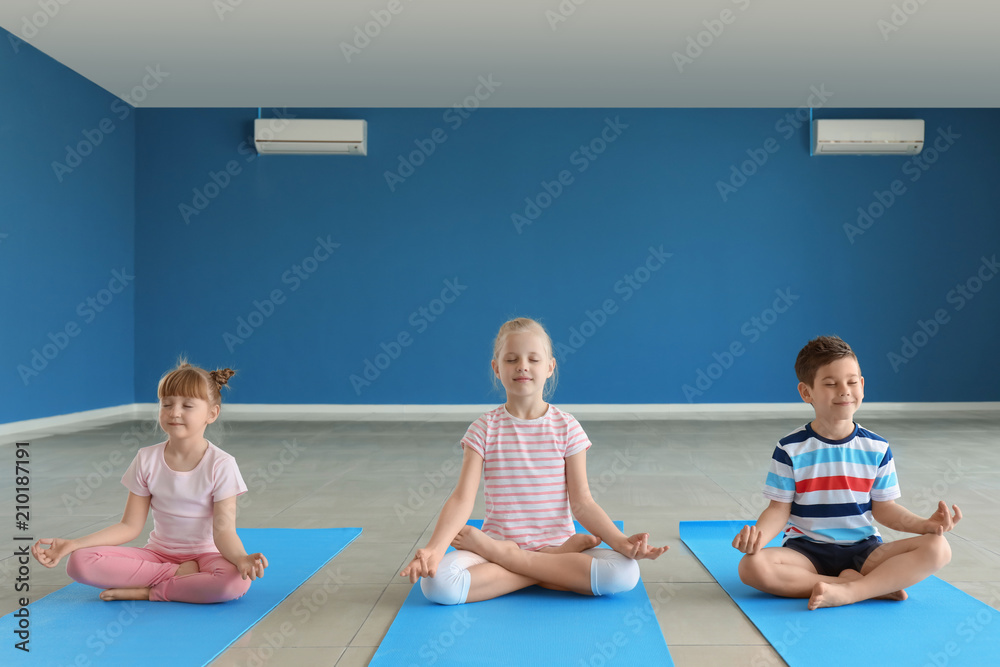 Little children practicing yoga indoors