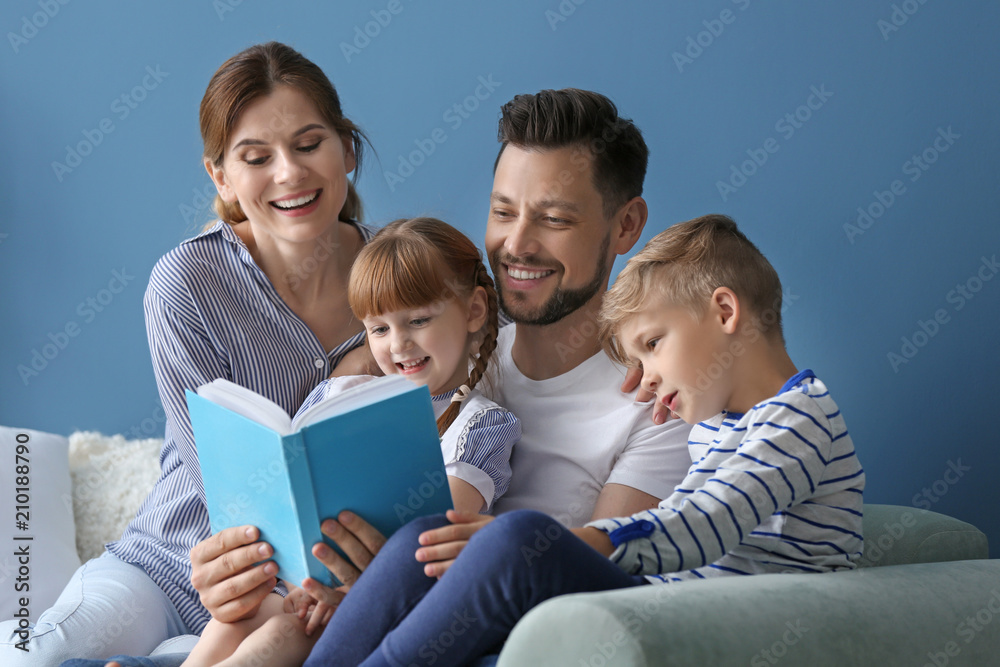 Parents and their children reading book together at home