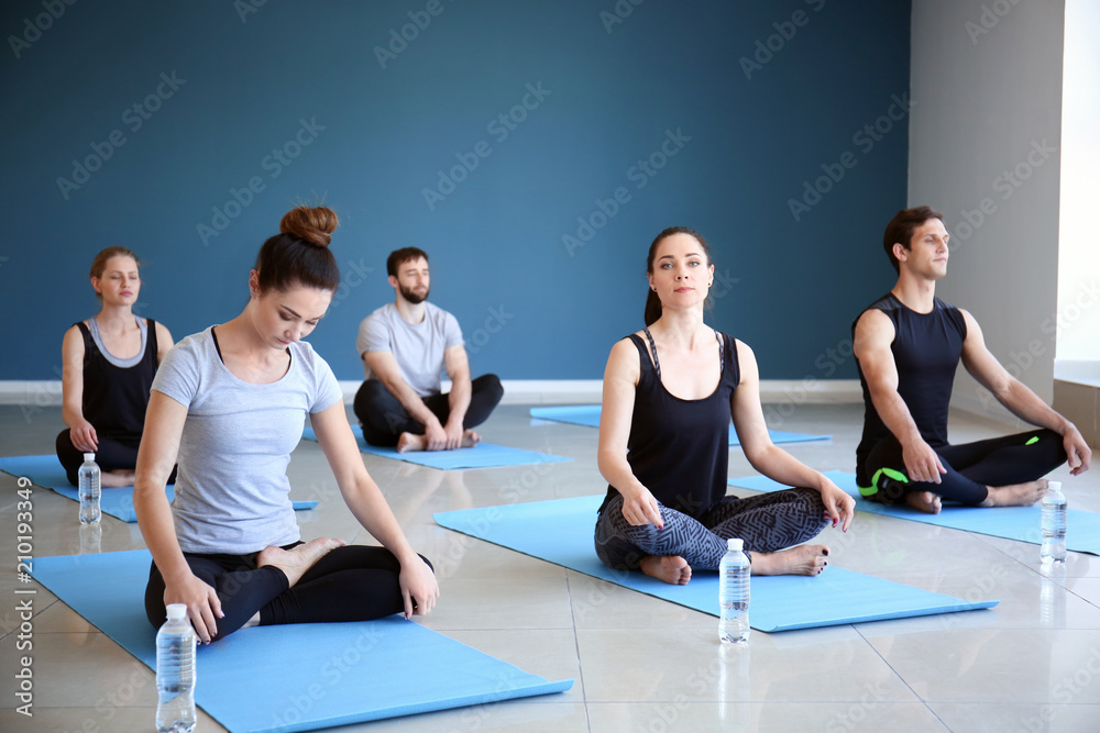 Group of people practicing yoga in gym