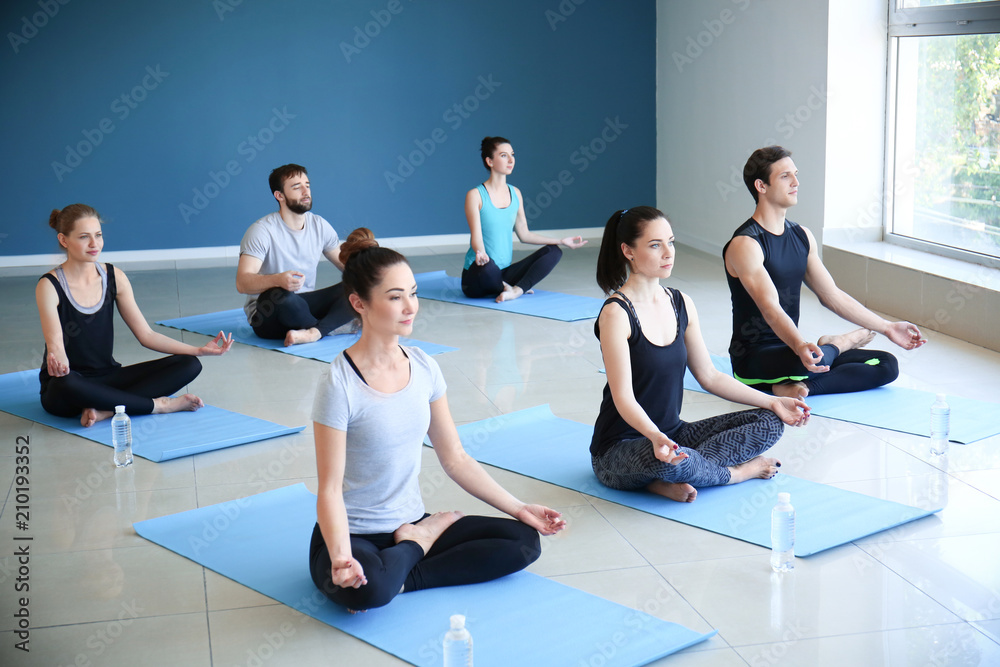 Group of people practicing yoga in gym