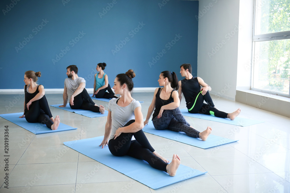 Group of people practicing yoga in gym