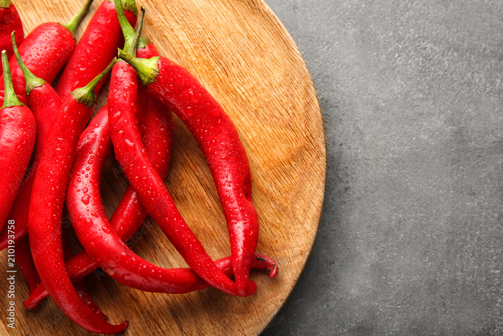 Plate with fresh chili peppers on grey background, closeup