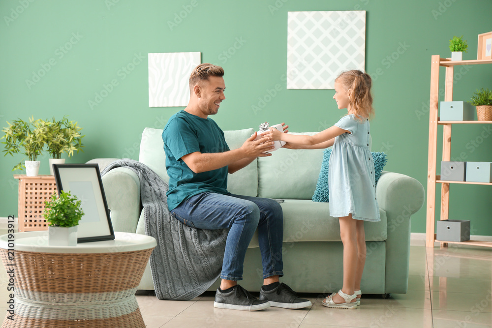 Cute little girl greeting her daddy with Fathers Day at home