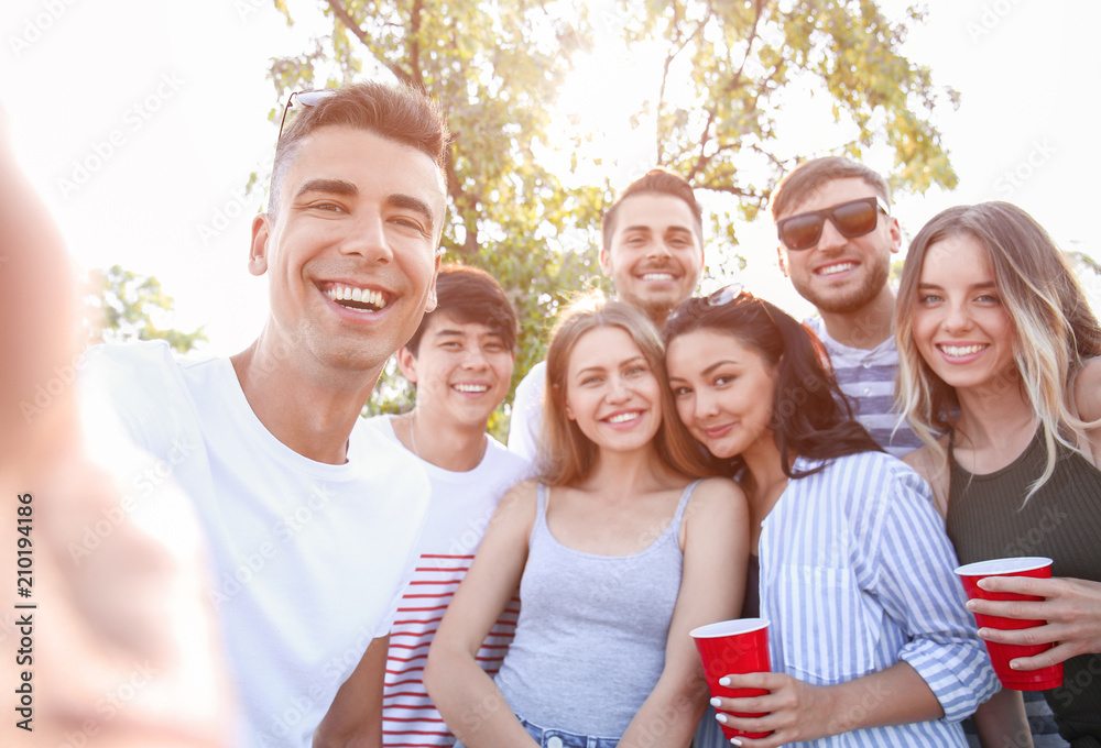 Group of attractive young people taking selfie outdoors