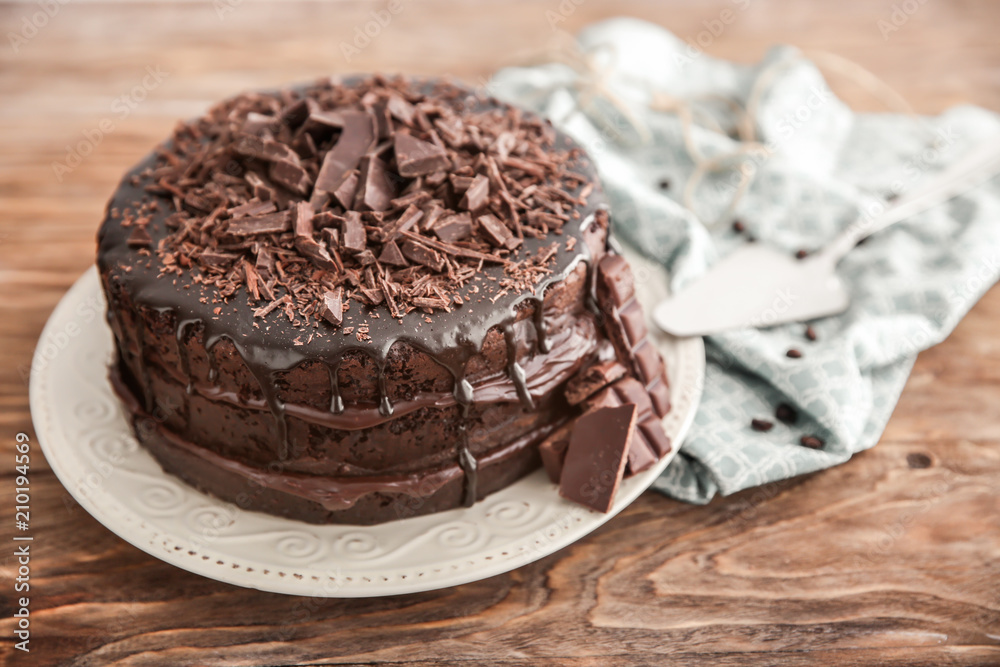 Plate with delicious chocolate cake on wooden table