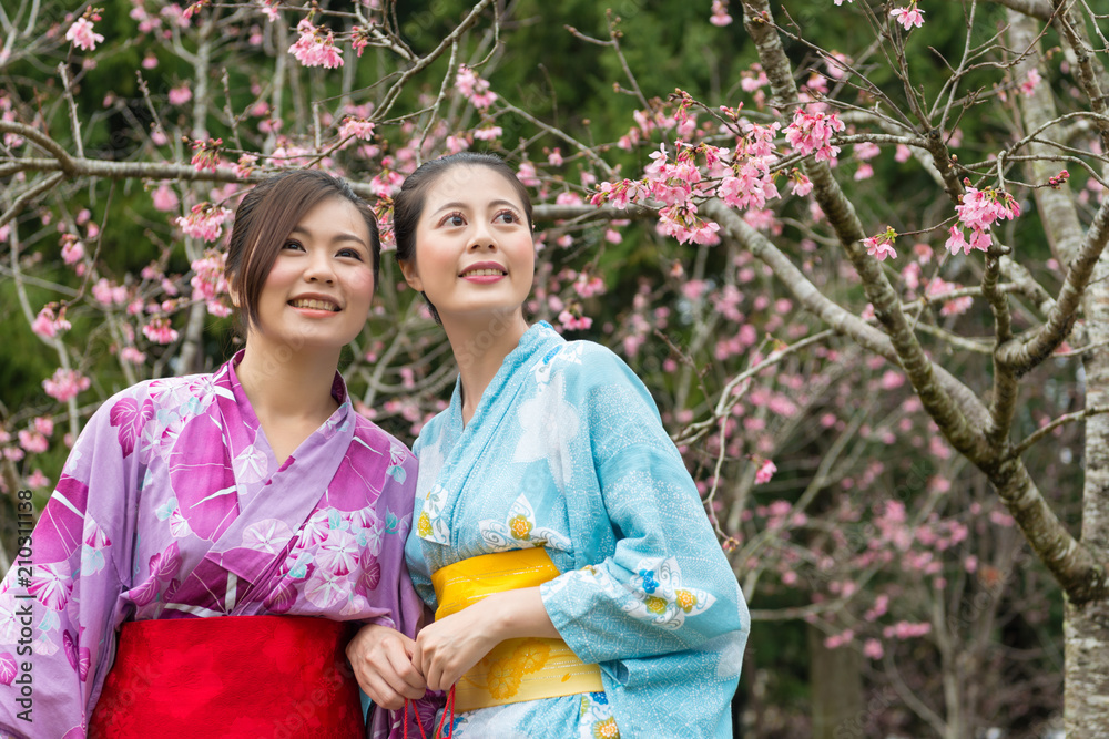 ladies stand in front the cherry tree and laugh