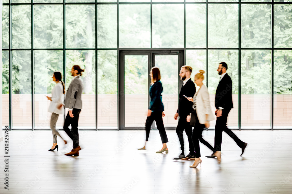 Business people walking at the modern hall on the window background indoors. long exposure image tec