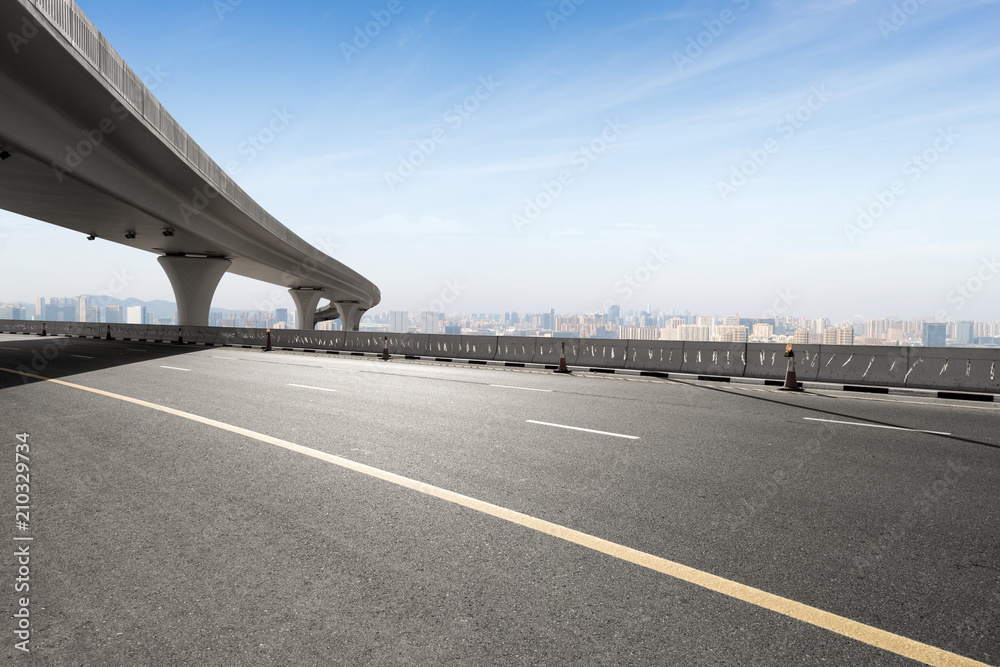 asphalt road with city skyline