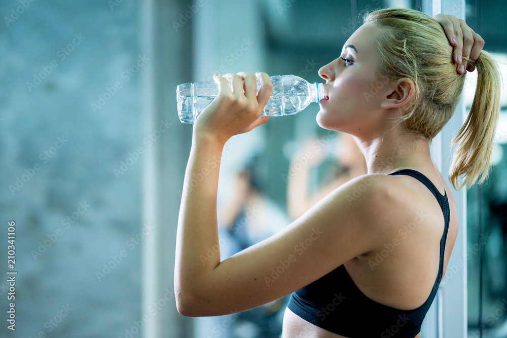 attractive caucasian woman relax with pure water after workout with happiness and joyful in gym heal