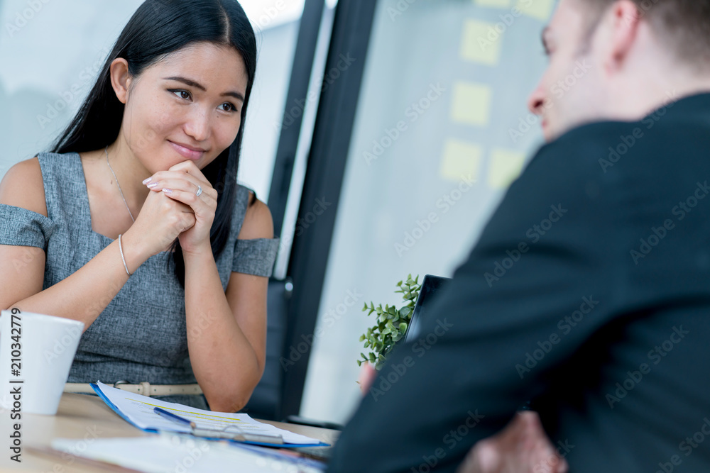 BUSINESS INTERVIEW WITH ASIAN WOMAN AND CAUCASIAN BOSS IN OFFICE