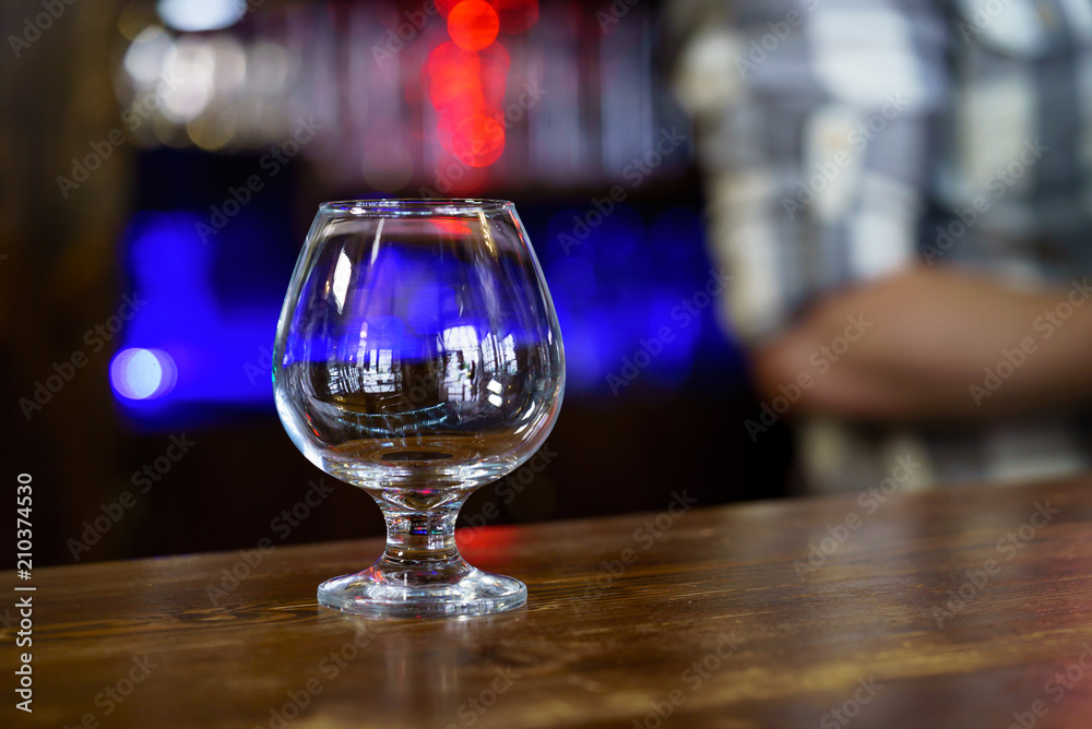 Clean empty glass on the bar. Blurred Background