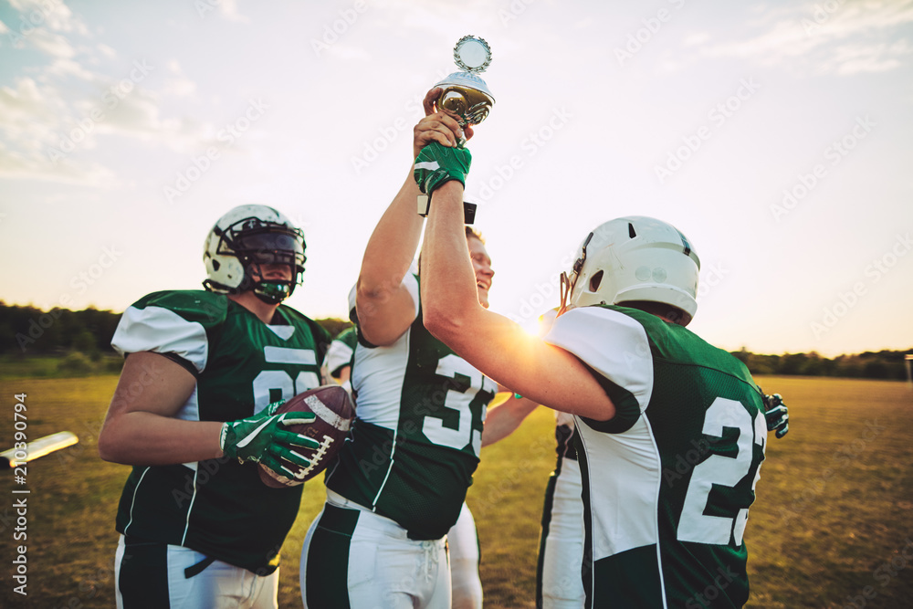 Football team celebrating with a trophy after winning the champi