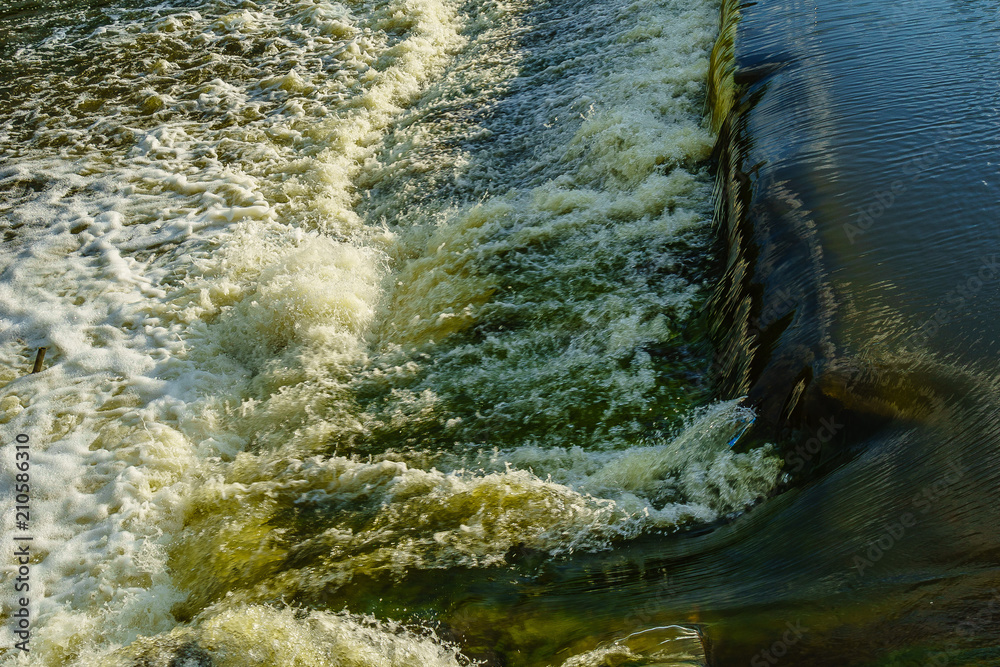 Seething water with foam, threshold on the river