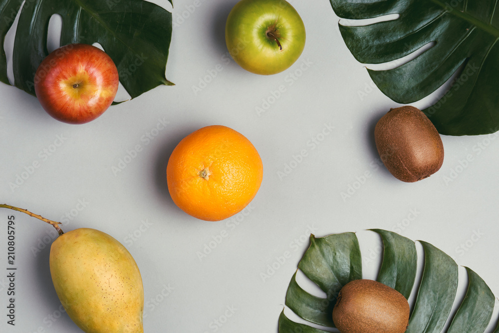 Orange, mango, apple and kiwi in gray background