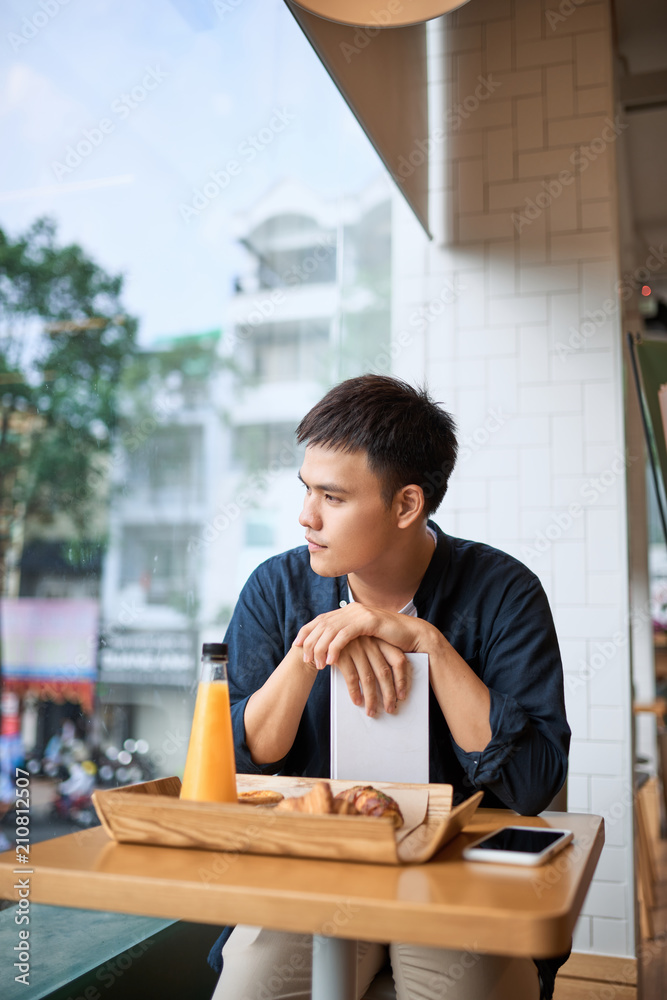 Men is sitting in the coffee shop, thinking. Bakery and tea time