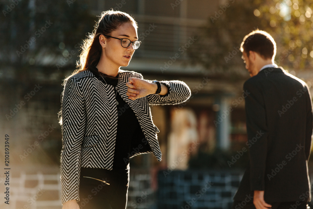 Businesswoman checking time while going to office