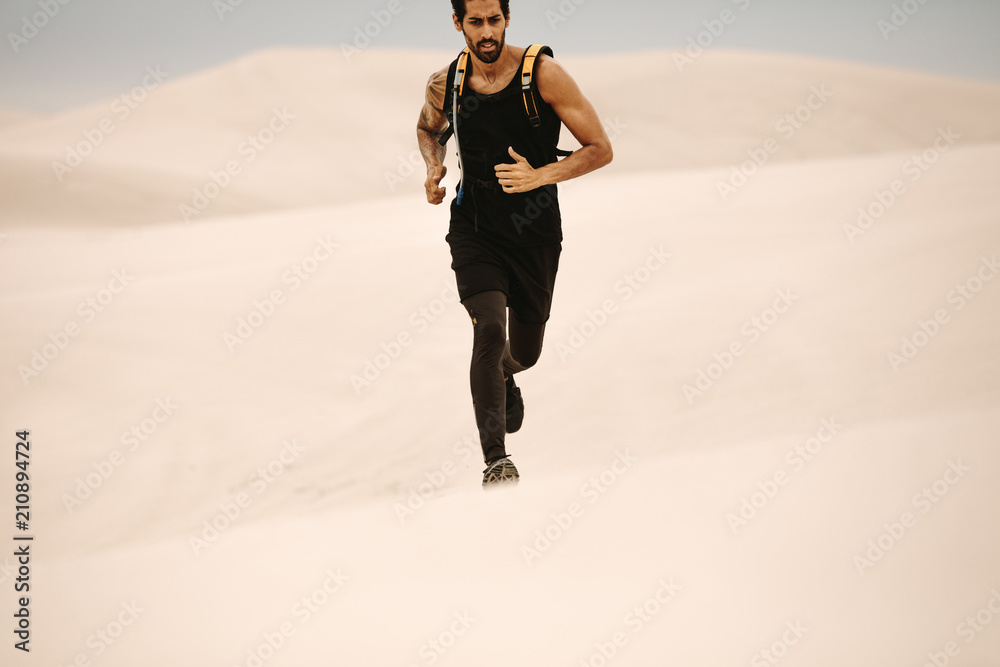 Man running on sand dunes