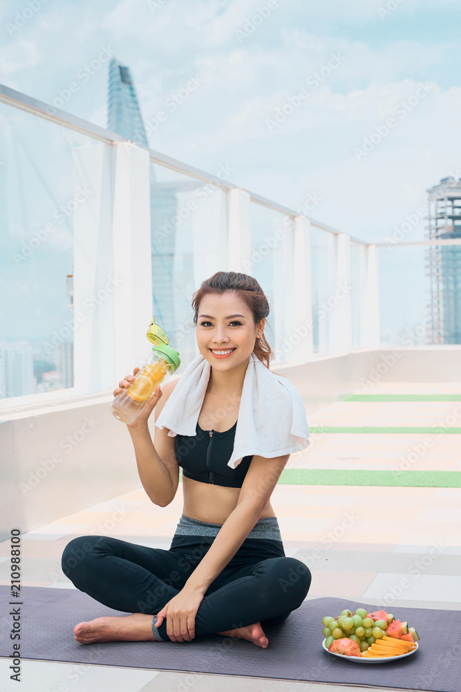 年轻女子锻炼后拿着水瓶休息