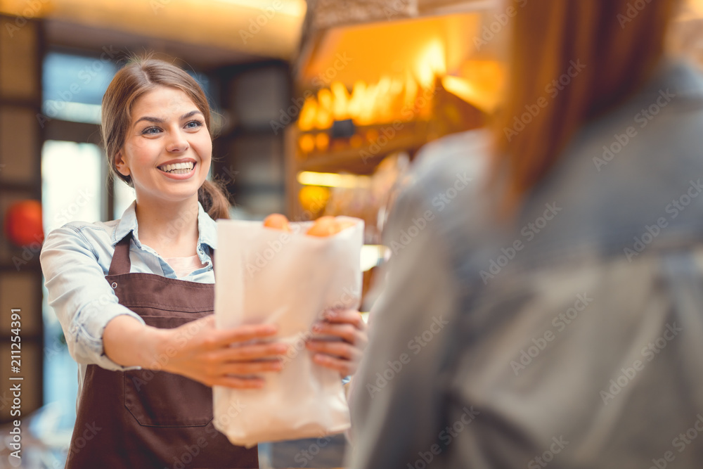 Young baker and customer at the counter