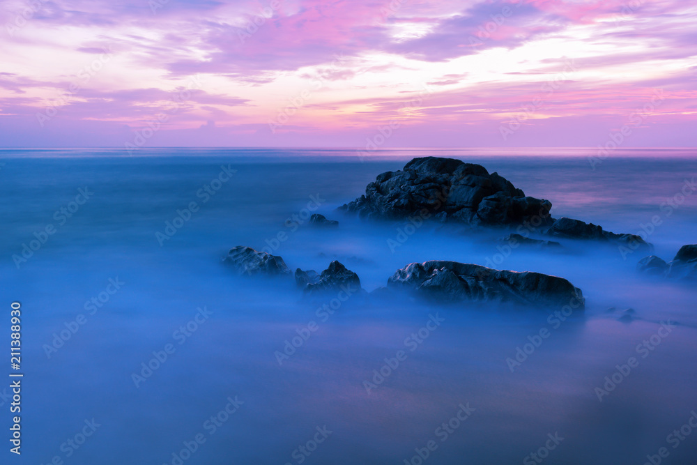 Long exposure image of Dramatic sky and wave seascape with rock in sunset scenery background,beautif