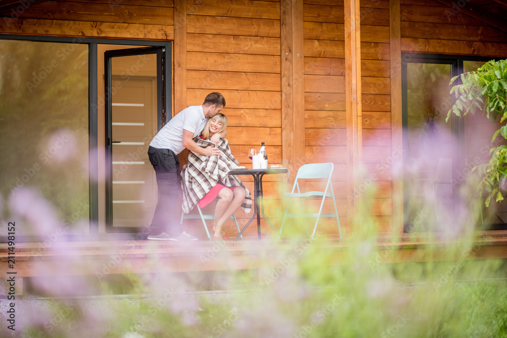 Young couple having a romantic dinner on the backyard of the wooden country house