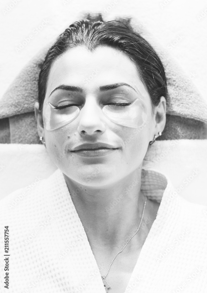 Woman relaxing with a golden eye mask treatment