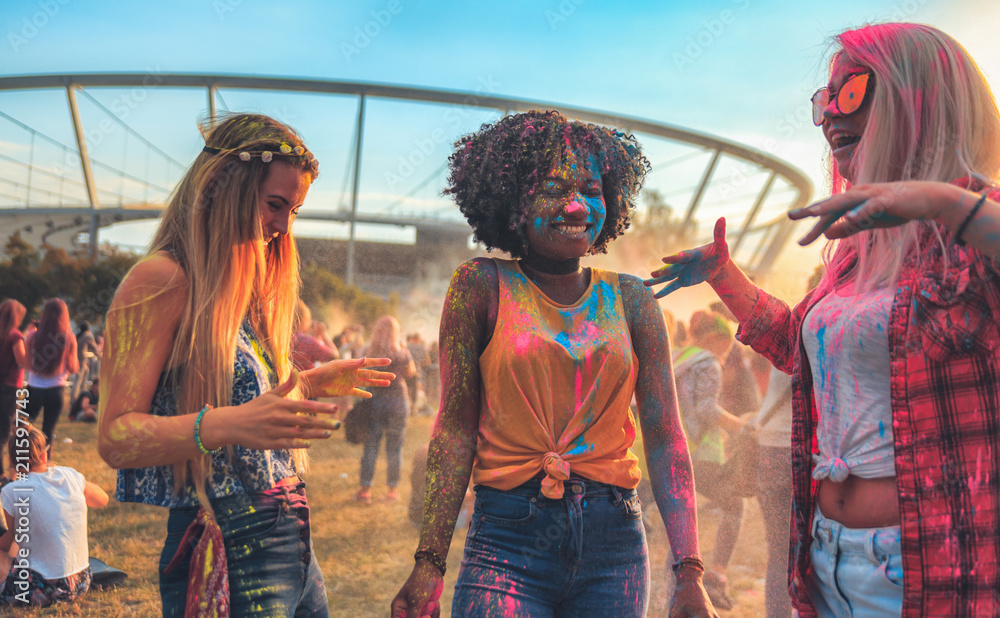 Multiethnic group of friends with colorful powder on clothes and bodies at summer holi festival havi