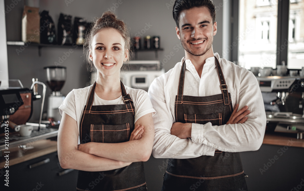 Small business owner, successful young baristas standing in front of their cafe