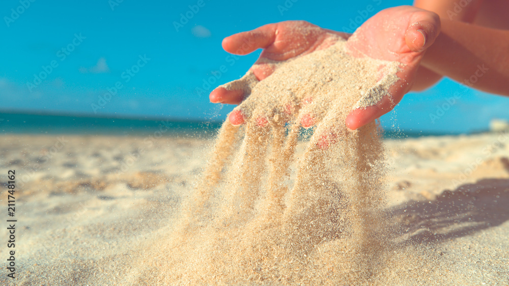 CLOSE UP: Unrecognizable woman lets breeze sweep away the sand from her hands.