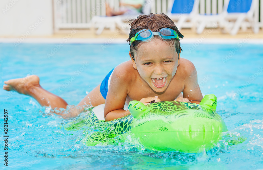 Boy having fun with inflatable toy in pool