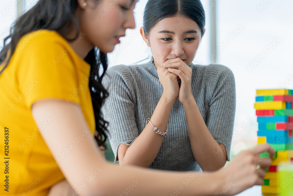 与亚洲女性朋友退出派对游戏，女性一起玩积木，充满乐趣和幸福