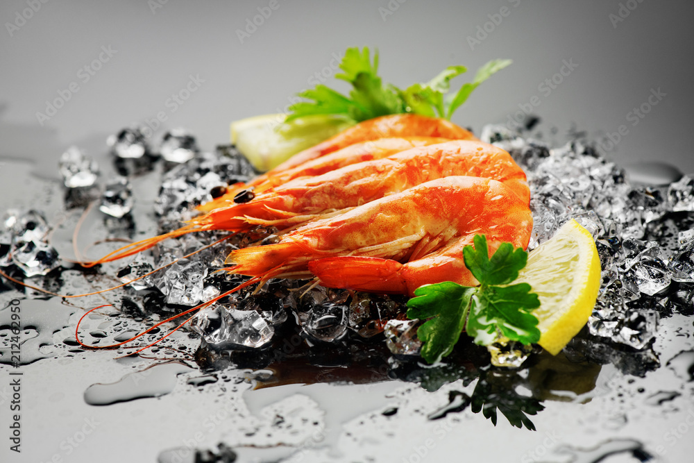 Shrimps. Fresh prawns on a black background. Seafood on crashed ice with herbs. Healthy food, cookin