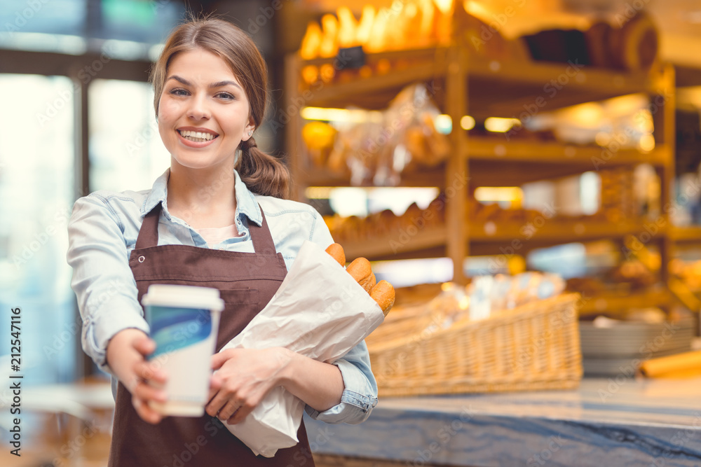 Smiling with coffee in a bakery