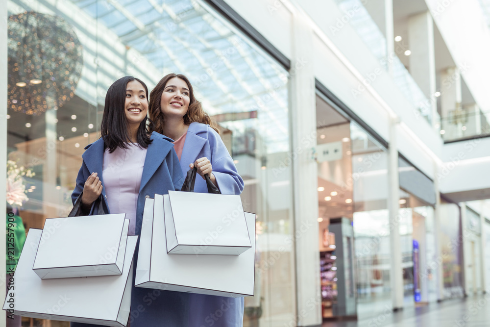 Smiling young women with shopping bags