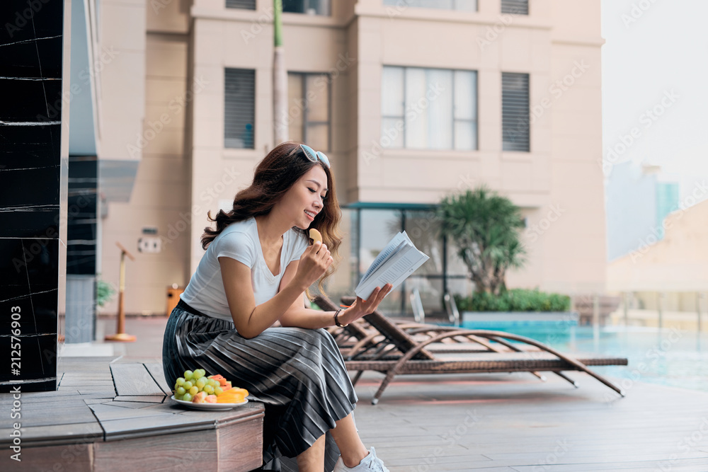 美丽开朗的女人的肖像，在度假胜地游泳的夏季放松和看书