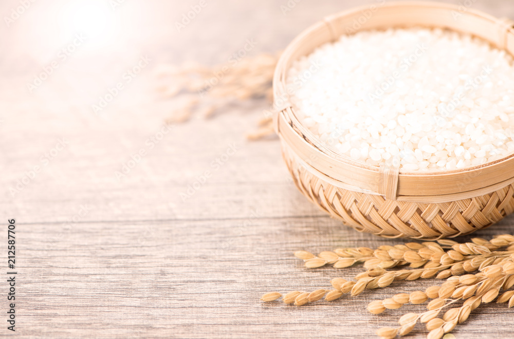 Close up raw rice in bowl on wooden background