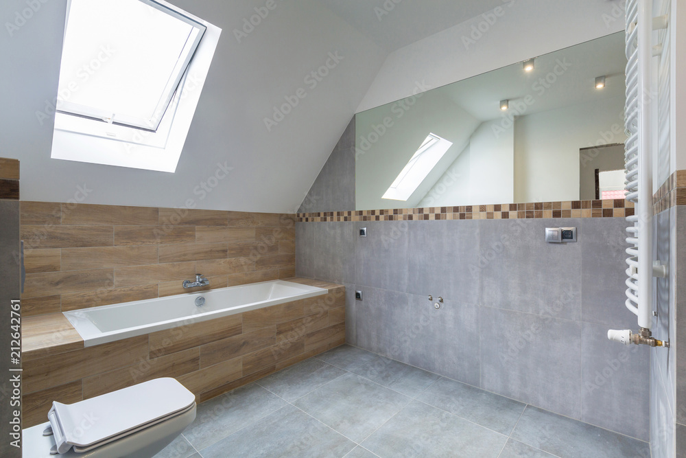 New bathroom interior in the house. Gray concrete tiles with wooden decor.