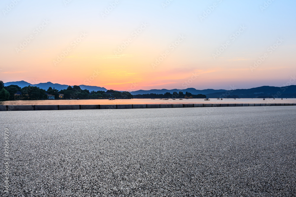 日落时空旷的柏油路和山丘剪影