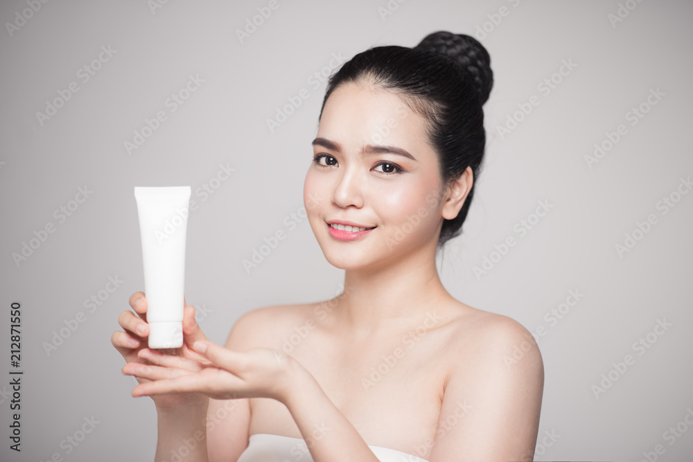 Beauty concept. Asian pretty woman with perfect skin holding cosmetic bottle