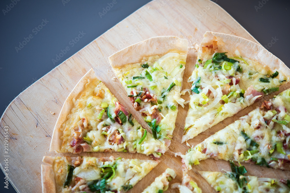 Original dünner Flammkuchen aus dem Elsass mit Zwiebeln, Speck und Sauerrahm Creme im Ofen gebacken 